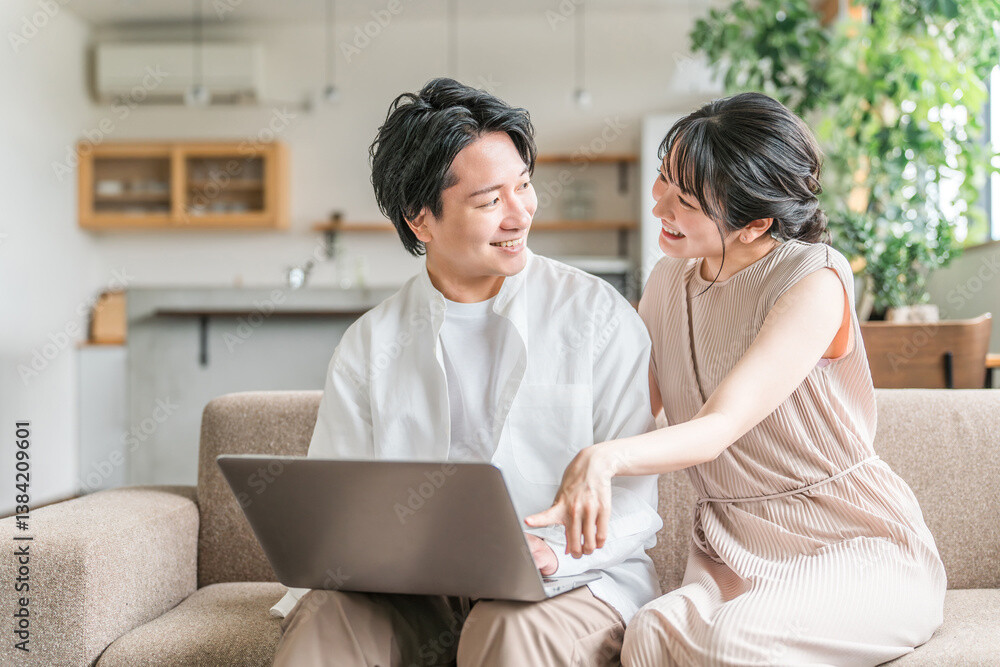 パソコン操作する夫婦